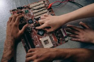 Close-up of hands repairing a motherboard, highlighting teamwork and electronics engineering.
